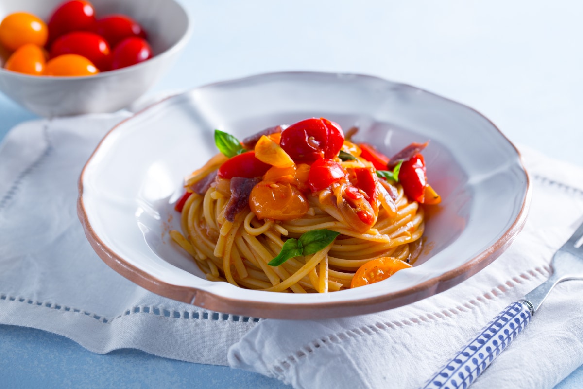 Pasta con tomatitos, anchoas y cebolla