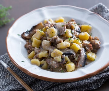 Ñoquis de patata con taleggio, setas y salchicha